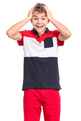 Portrait of happy surprised teen boy, isolated on white background. Funny child looking at camera in shock or amazement touching his head with hands. Handsome caucasian young teenager.