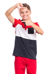 Portrait of teen boy making frame with hands and fingers with happy face, isolated on white background. Positive cute teenager making square with his fingers, looking at camera and pleasantly smiling.