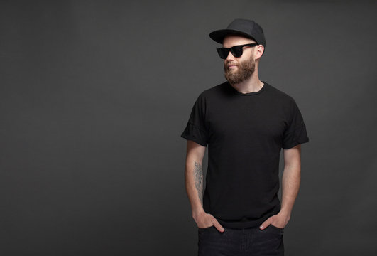 Hipster handsome male model with beard wearing black blank t-shirt with space for your logo or design