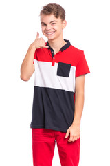 Portrait of teen boy making phone sign with his fingers, isolated on white background. Handsome caucasian young teenager smiling, showing call me hands gesture. Happy cute child looking at you camera.