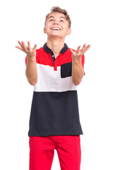 Portrait of teen boy raised hands and trying to catch something. Cute caucasian young teenager smiling and looking up, isolated on white background. Joyful child having fun.