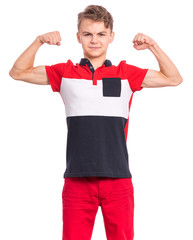 Portrait of funny teen boy raised his hands and shows biceps, isolated on white background. Serious handsome teenage young boy shows biceps. Strong child flexing biceps and looking at camera.