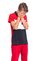 Portrait of teen boy with sad expression covering face with hands while crying. Unhappy child crying, not showing his tears. Upset caucasian young teenager, isolated on white background.