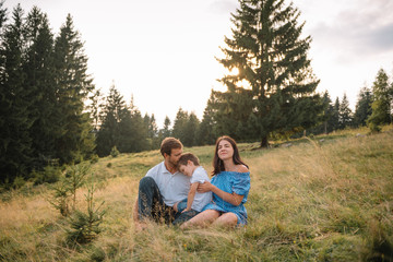 Fototapeta premium Young family with child resting on a mountain. vacation in the national park