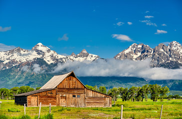 Old mormon barn in Grand Teton Mountains with low clouds. Grand Teton National Park, Wyoming, USA.