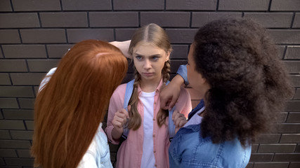 Cruel schoolgirls pushing younger teenager against wall, psychological pressure