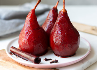 Red wine poached pears in white plate, delicious french dessert, close-up - obrazy, fototapety, plakaty