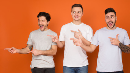 Excited guys pointing fingers away and looking aside, orange background