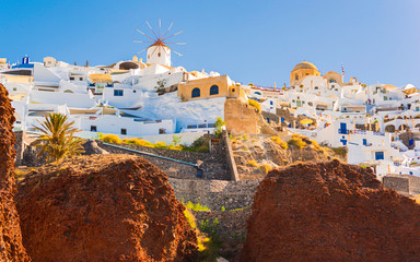 Handheld view of the coastal cliffs of Santorini as seen from a boat on the water.
