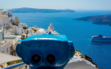 Beautiful view of white typical village and Aegean Sea i. View of blue domed churches -famous tourist attraction in Greece.