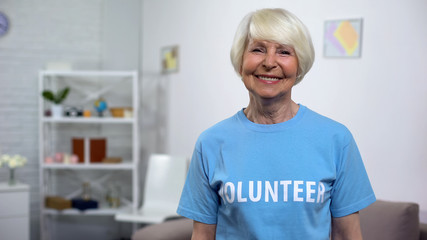 Obraz premium Smiling senior lady in volunteer t-shirt looking camera, charity organization