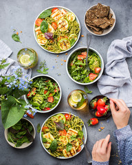 Vegetarian perfect lunch. Iced tea with lime, mint and basil, Green pasta with grilled cheese, grilled zucchini, nuts and herbs. Salad with strawberries, arugula and avocado