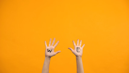 We written palms on orange background, volunteers raising hands, togetherness