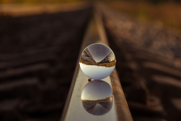 the mirror strip of the railway is reflected in the crystal ball