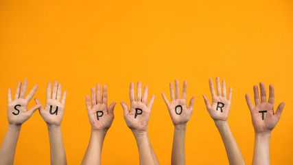 Support written palms on orange background, teamwork cooperation, activists