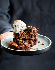 Zucchini and chocolate cake with ice cream and berries in the hands