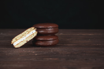 Chocolate chip cookies on a dark wooden table. Cookies cut in half. Background image. Tasty breakfast.