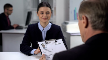 Employer holding curriculum vitae of female applicant, job interview, hiring