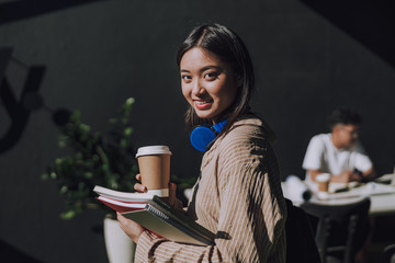 Amazing female Asian student having coffee break