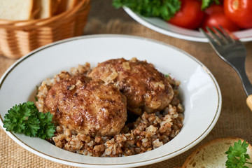 Fried meat cutlets with buckwheat in a white bowl
