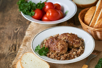 Fried meat cutlets with buckwheat in a white bowl
