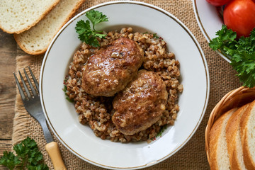 Fried meat cutlets with buckwheat in a white bowl