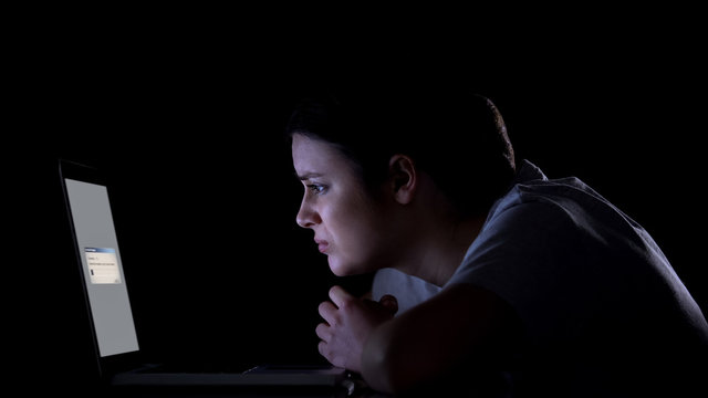Worried woman waiting for files downloading or upgrading of software on laptop