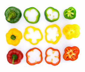 Set of sliced green yellow and red bell pepper section pieces isolated over white background, view above