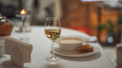 a glass of white wine on the table on the background of food