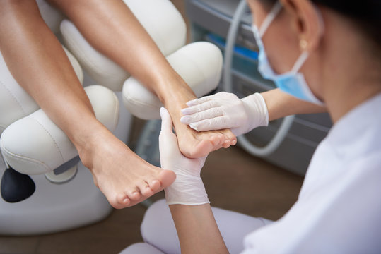 Pedicurist Gently Massaging Woman Leg After Pedicure