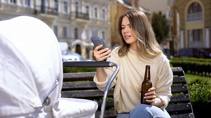 Indifferent mom chatting smartphone drinking beer instead taking care of baby