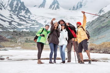 Group of happy tourists taking selfie photo in mountains