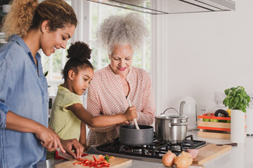 Three generations of family cooking a meal together