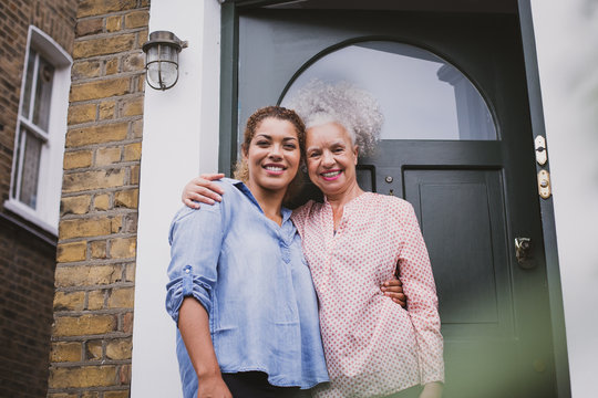 Portrait of senior female with daughter outside home