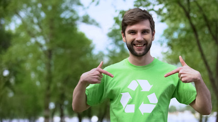 Young environmental activist pointing at recycling symbol t-shirt, segregation