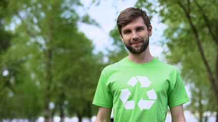 Handsome man in recycle symbol t-shirt looking camera, environmental protection