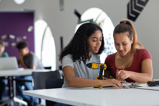 High school students working on a robotic arm in class