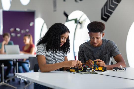 High school students working on a robotic arm in class