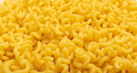 Macro shot of raw yellow cavatappi pasta texture background