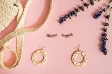 collection collage of women's accessories. Natural eco straw bag, bamboo earrings, eyelashes for women on a pink background. The concept of summer and girlhood.