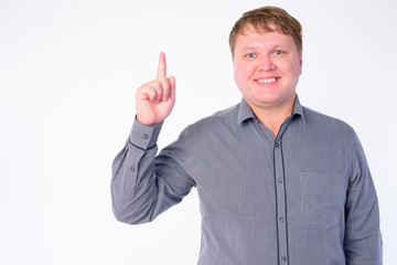 Portrait of happy overweight businessman pointing finger up