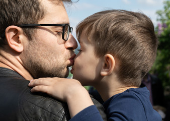 ather kisses his little son