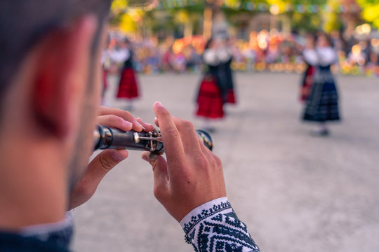 Detail of dulzaina, typical instrument. Person who dances in the background, traditional dance of Segovia.