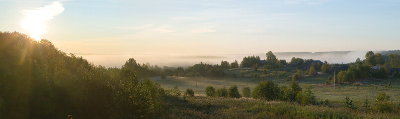 Fototapeta na wymiar Beautiful panorama of a rural place with dawn and fog