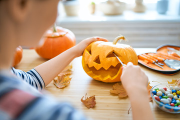 Woman is carving pumpkin
