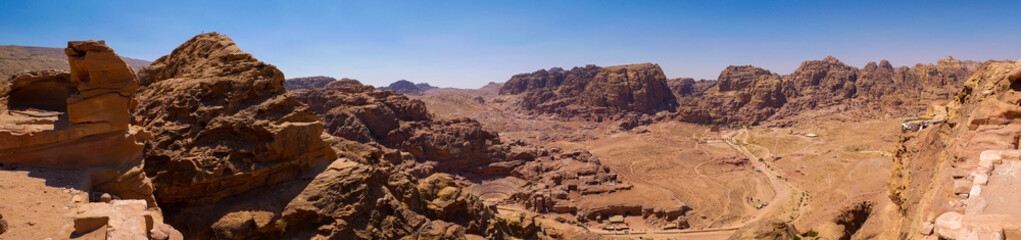 Fototapeta na wymiar View of the valley of the historic site of Petra, Jordan, orange desert full of temples and a roman amphitheatre, seen from aerial perspective from a sandstone mountain