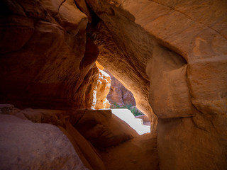 Rock tunnel, small cave between sandstone mountains, illuminated by the sun