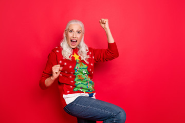 Photo of enthusiastic funky retro model granny having fun good mood gesturing raising fists up wearing jeans denim bright jumper isolated vivid color background