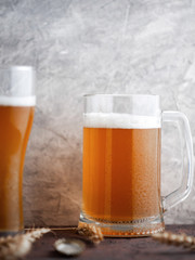 Glass and mug of beer. Wheat light beer unfiltered on a gray background