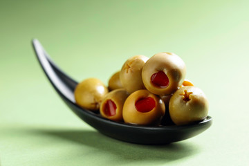 Appetizing olives stuffed with red pepper in small  bowl.